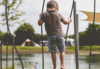 Bambino che gioca su un ponte di legno al lago al Camping de Bovenberg, Overijssel, Paesi Bassi.