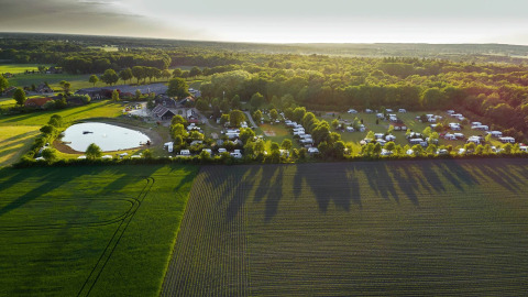 Vista aerea di Camping de Bovenberg a Overijssel, Paesi Bassi, con roulotte, stagno e campi verdi.
