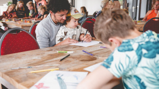 Kinderen en volwassenen doen mee aan knutselactiviteiten op Camping de Bovenberg in Overijssel, Nederland.