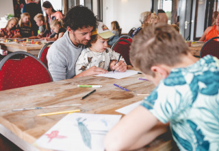 Kinderen en volwassenen doen mee aan knutselactiviteiten op Camping de Bovenberg in Overijssel, Nederland.