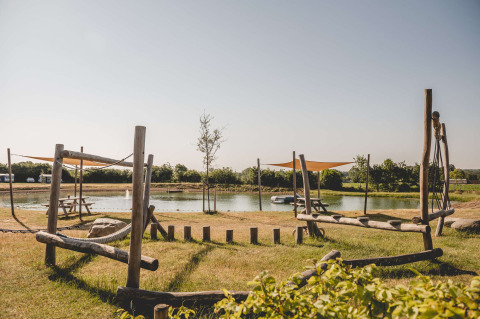 Parco giochi con strutture in legno e stagno a Camping de Bovenberg, Overijssel, Paesi Bassi.