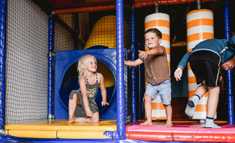 Bambini che giocano in un parco giochi al coperto al Camping de Bovenberg, Overijssel, Paesi Bassi.