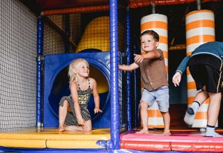 Bambini che giocano in un parco giochi al coperto al Camping de Bovenberg, Overijssel, Paesi Bassi.