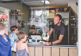 Bambini con asciugamani acquistano gelato al chiosco di Camping de Bovenberg, Overijssel, Paesi Bassi.