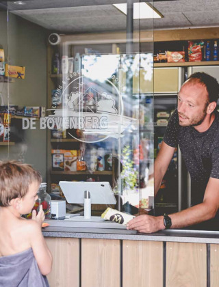 Niños en toallas piden helado en la tienda de Camping de Bovenberg en Overijssel, Países Bajos.