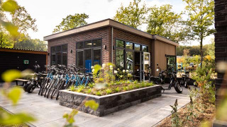 Alquiler de bicicletas en un parque vacacional moderno rodeado de vegetación en Beekbergen, Gelderland.