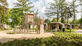 Parque infantil y casas vacacionales modernas en Bospark Ede, rodeado de naturaleza en Gelderland, Países Bajos.