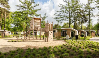 Parque infantil y casas vacacionales modernas en Bospark Ede, rodeado de naturaleza en Gelderland, Países Bajos.