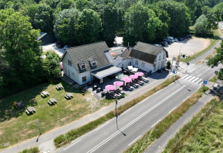 Luchtfoto van Camping de Boskant in Limburg, Nederland, met terras, picknicktafels en groene omgeving.