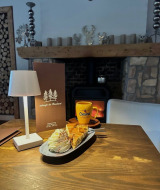 Ambiente acogedor con chocolate caliente, pastel y nata junto a la chimenea en Camping de Boskant, Limburg.