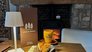 Gemütliches Café mit heißer Schokolade, Kuchen und Sahne vor Kamin im Camping de Boskant, Limburg.