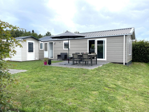 Vista exterior del Chalet Brilon en Camping & Ferienpark Brilon, Alemania, con terraza y muebles de jardín.