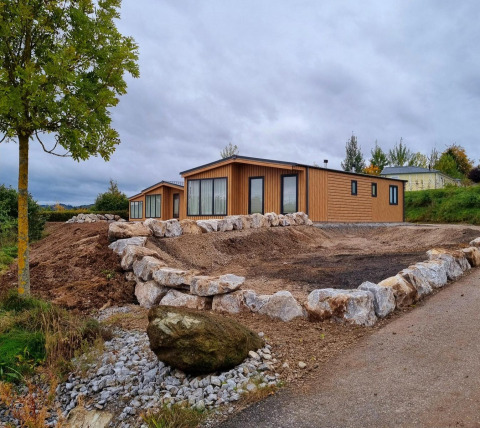 Chalet Enzian en Camping & Ferienpark Brilon, Alemania, con rocas y naturaleza alrededor de la cabaña.