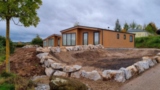 Chalet Enzian op Camping & Ferienpark Brilon in Duitsland, met stenen en een natuurlijke omgeving.