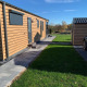 Solrigt billede af Chalet Bergrose ved Camping & Ferienpark Brilon i Tyskland med grøn græsplæne.