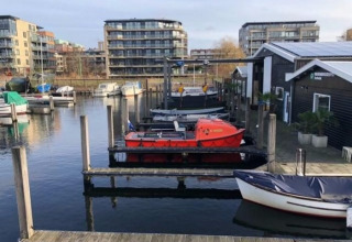 Beeld van aanlegsteigers en moderne appartementen in Marina Parcs - Jachthaven De Hoop, Noord-Holland.