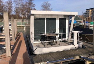 Flydende feriebolig fortøjet ved Marina Parcs - Jachthaven De Hoop i Nordholland, Nederlandene, på en solrig dag.