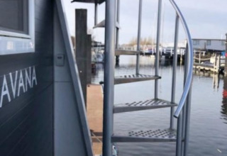 Udendørs vindeltrappe ved kaj med udsigt til både, Marina Parcs - Jachthaven De Hoop, Nordholland, Holland.