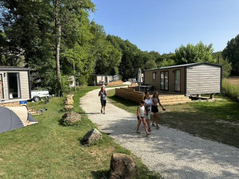 Ferieboliger ved Mobilhome Toulouse, La Draille i Frankrig, med folk der går på grussti og omgivet af natur.