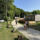 Ferieboliger ved Mobilhome Toulouse, La Draille i Frankrig, med folk der går på grussti og omgivet af natur.