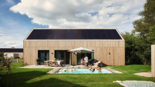 Lodge Unbrick One avec sauna, piscine et panneaux solaires, famille détendue devant cabane moderne.