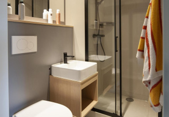 Salle de bain moderne dans la Nature Wellness Suite Hot tub au Camping Sevink Molen, Pays-Bas, avec douche.