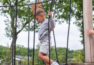 Un bambino attraversa un ponte di corde al Recreatiepark Beekbergen, un parco vacanze nel Gelderland, Paesi Bassi.