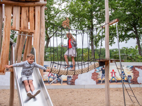 Des enfants jouent sur un toboggan et un pont de corde au Recreatiepark Beekbergen, Gelderland, Pays-Bas.