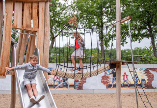 Niños jugando en un tobogán y un puente de cuerda en el Recreatiepark Beekbergen, Gelderland, Países Bajos.