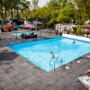 Outdoor swimming pool and playground at Recreatiepark Beekbergen holiday park, Gelderland, Netherlands, on a sunny day.