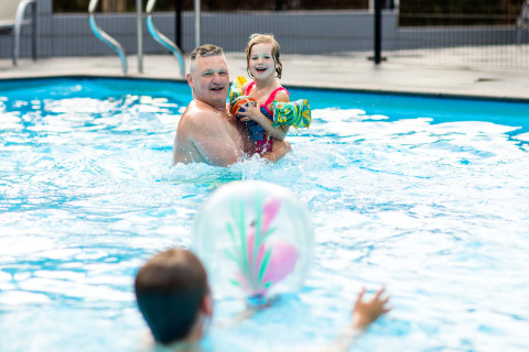 Familia disfrutando y jugando en la piscina de Recreatiepark Beekbergen, Gelderland, Países Bajos.