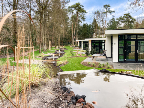 Moderne Ferienhäuser im Recreatiepark Beekbergen in Gelderland, Niederlande, umgeben von Natur.