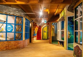 Binnenhal in Resort Veluwe, Gelderland, Nederland, met speelse deuren en kleurrijke decoratieve elementen.