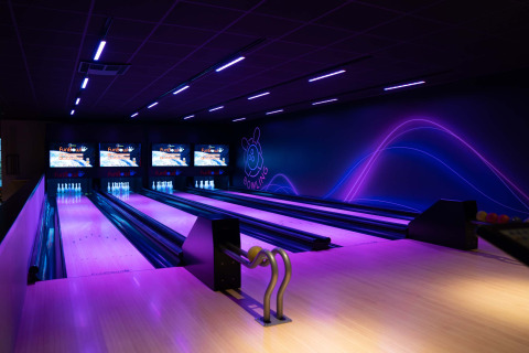 Allée de bowling moderne éclairée en violet au Resort Veluwe, parc de vacances à Gelderland, Pays-Bas, de nuit.