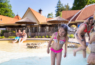 Enfants jouant dans la pataugeoire avec jets d'eau au parc de vacances Resort Veluwe en Gueldre, Pays-Bas.