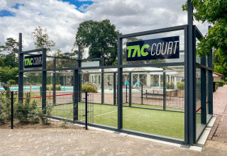 TAC Court op Resort Veluwe, vakantiepark in Gelderland, Nederland, met zwembad op de achtergrond zichtbaar.