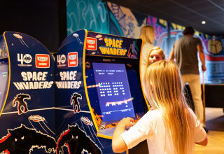 Kind spielt Space Invaders an einem Arcade-Automaten im Resort Veluwe, Gelderland, Niederlande.
