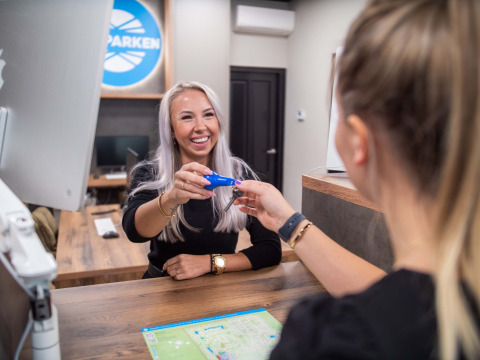 Deux femmes échangent une clé à la réception de Bospark Ede, un parc de vacances à Gelderland, Pays-Bas.