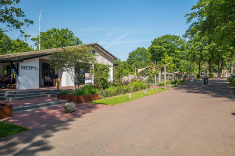 Ingresso e reception del parco vacanze Bospark Ede circondati da alberi a Gelderland, Paesi Bassi.