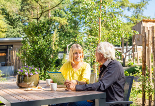 Twee senioren genieten buiten van koffie bij Bospark Ede, een vakantiepark in Gelderland, Nederland.
