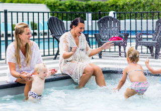 Deux femmes et trois jeunes enfants jouent près de la piscine au Bospark Ede, un parc de vacances en Gueldre, Pays-Bas.