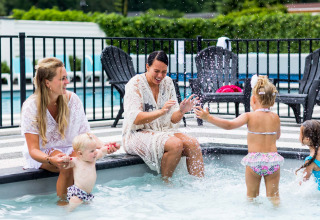 Twee vrouwen en drie kinderen genieten van plezier aan het kinderbad bij Bospark Ede in Gelderland.