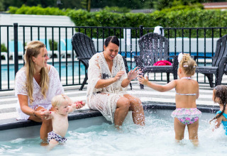 Dos mujeres y tres niños disfrutan juntos en la piscina infantil de Bospark Ede en Gelderland, Países Bajos.