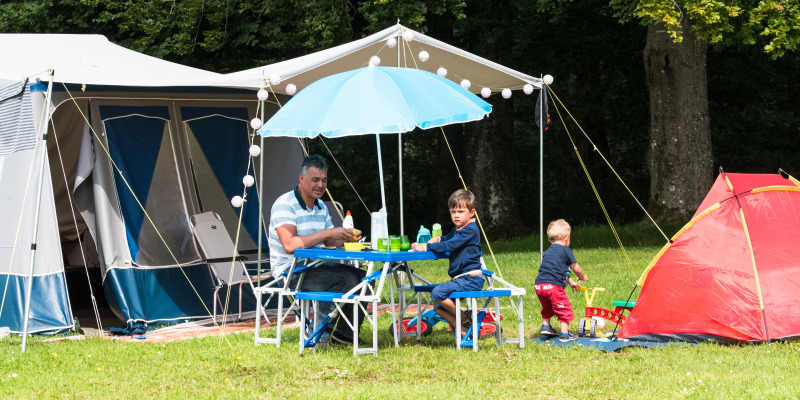 Familie genießt Mahlzeit und Zeit im Freien beim Camping La Colline im belgischen Luxemburg, Belgien.