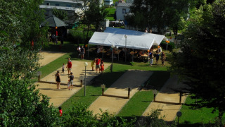 Vista de Camping la Roche con personas, carpas y senderos en un entorno verde de Limburgo, Bélgica.
