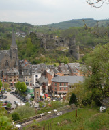 Blick auf Camping la Roche, einen Ferienpark in Limburg, Belgien, mit Kirche, Ruinen und Hügeln.