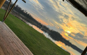 Vista desde una tienda safari en Camping de Kleine Wielen, Países Bajos, con lago y puesta de sol.