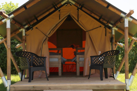 Tienda safari Duo Lodge en Camping de Boomgaard en Bélgica, con dos sillas plásticas en una tarima.