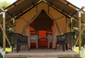 Tienda safari Duo Lodge en Camping de Boomgaard en Bélgica, con dos sillas plásticas en una tarima.