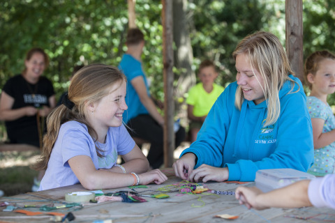 Niños realizan manualidades en una mesa en el Camping Sevink Molen, parque vacacional en Gelderland, Países Bajos.